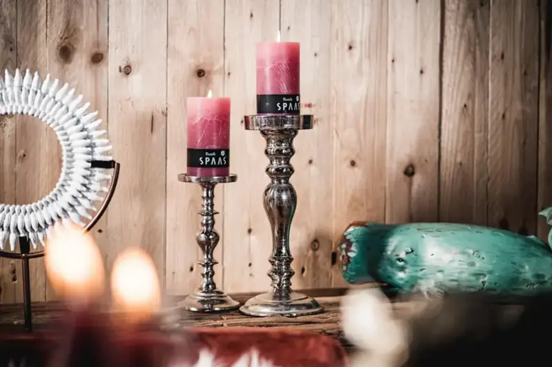 Silberne Kerzenständer mit roten Stumpenkerzen auf einem Holztisch